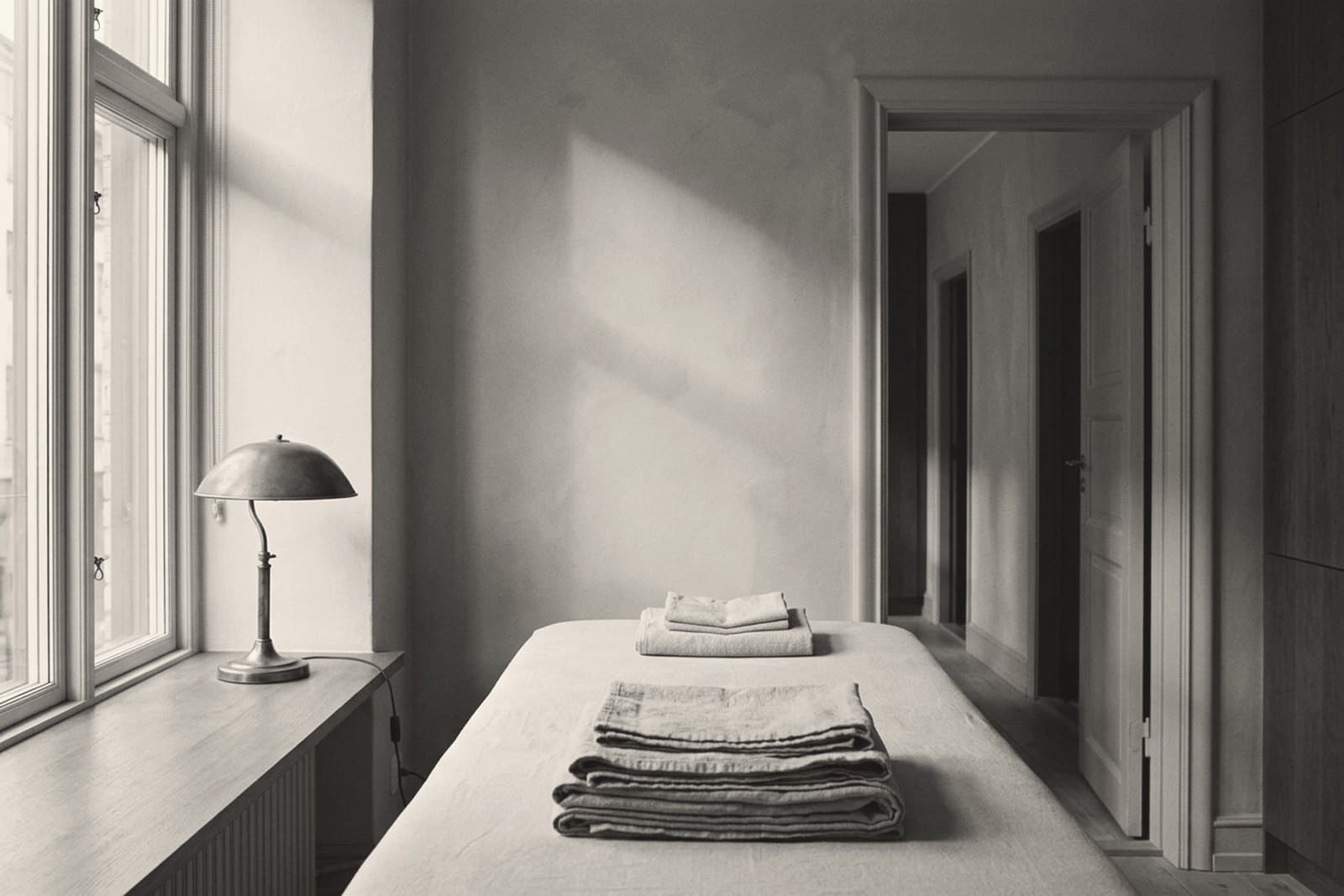 A prepared and empty treatment room in a small med spa, lit by the window